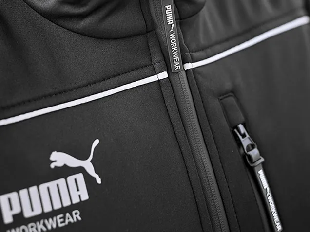 Nahaufnahme des Reißverschlusses einer schwarzen Workwear-Jacke mit dem PUMA-Logo.