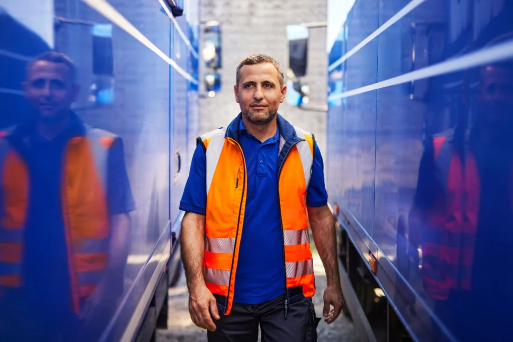Warnkleidung bei innerbetrieblichem Verkehr Mitarbeiter trägt eine orangefarbene Warnweste in einem Betriebsbereich