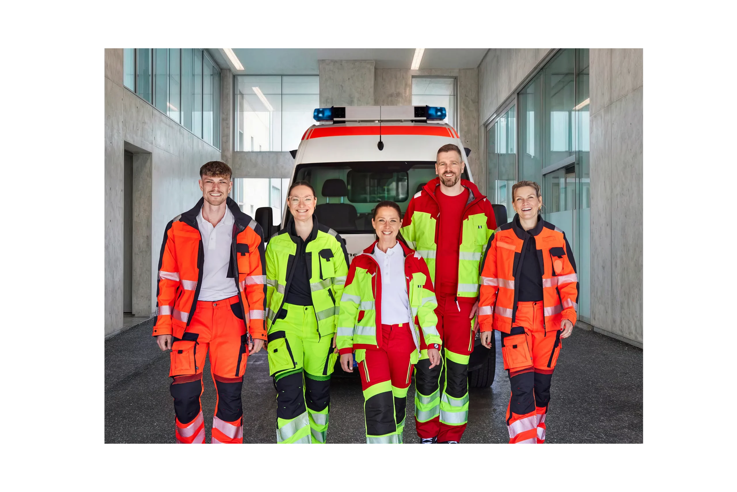 Gruppenbild mit drei Frauen und zwei Männern die in Rettungsdienstkleidung vor einem Rettungswagen stehen
